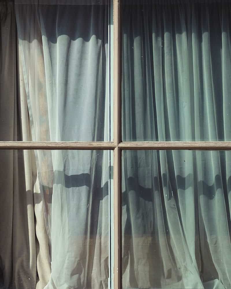 A curtain seen through a window