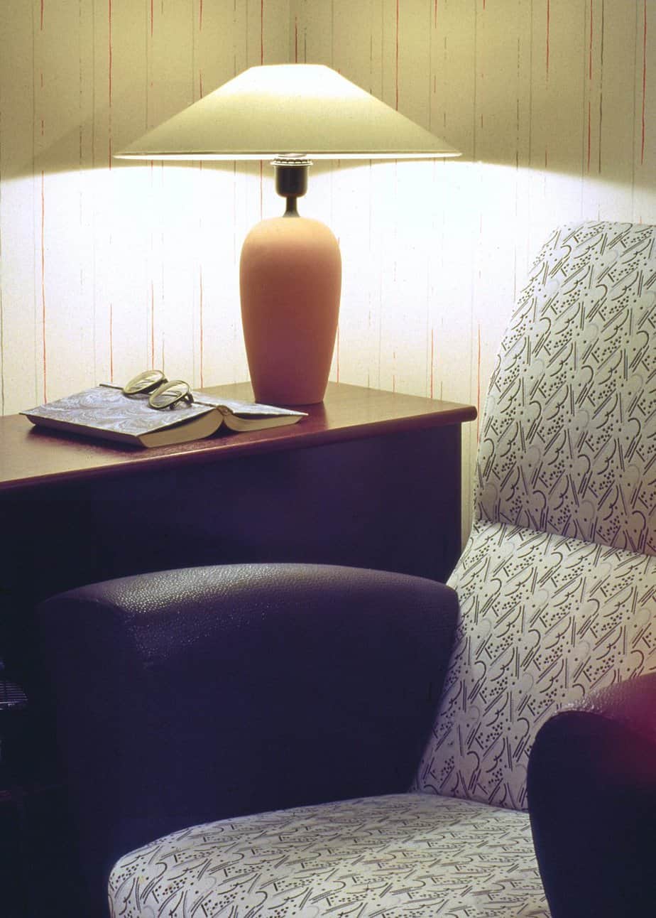 Resting corner with an armchair and side table with lit lamp