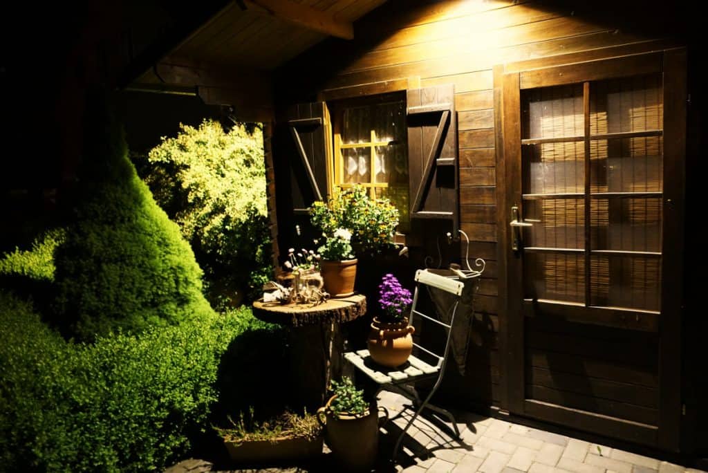 Shed entryway with outdoor lighting and small seating area