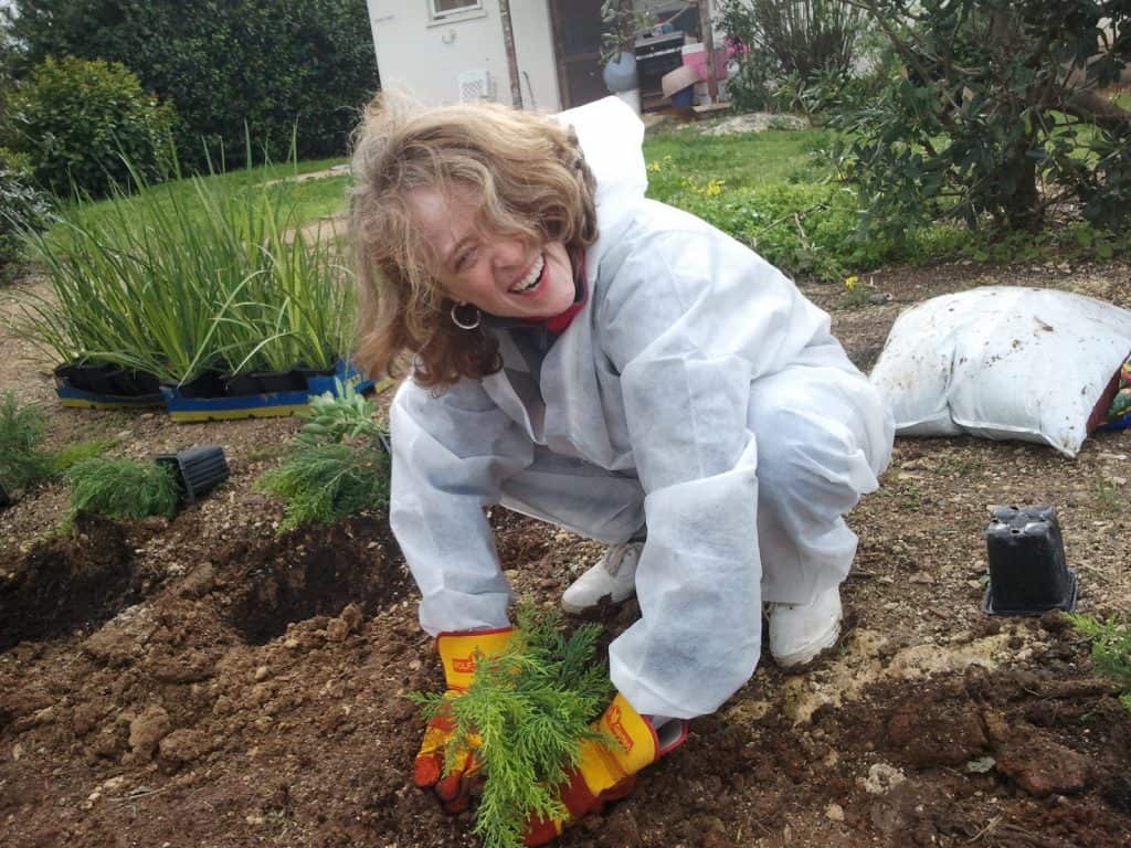 A happy woman poses in the camera while gardening