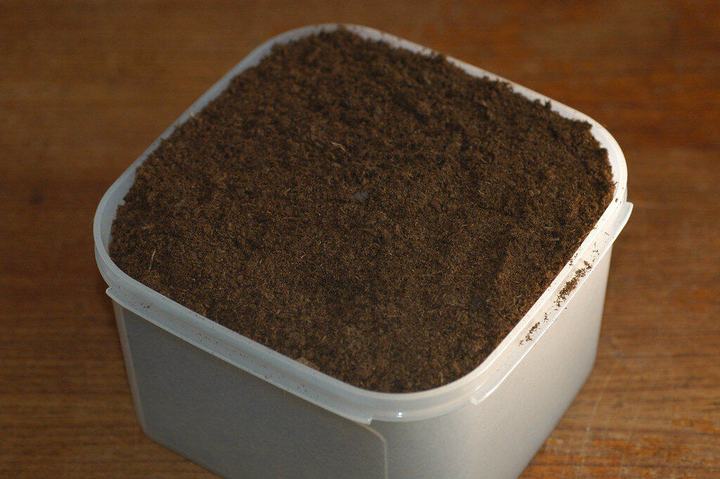 A small container filled with peat moss.