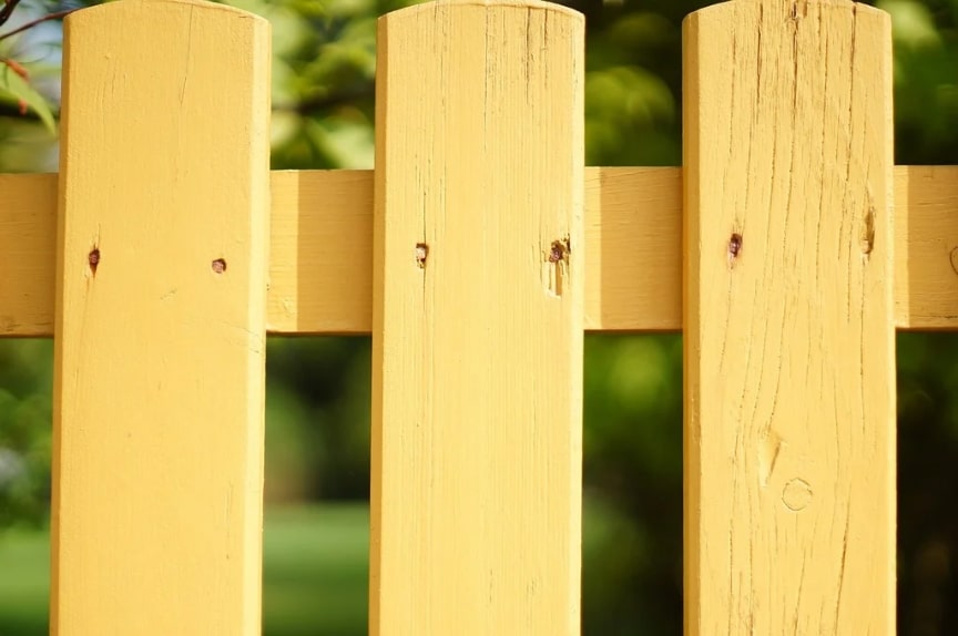 Yellow-painted wooden fence.