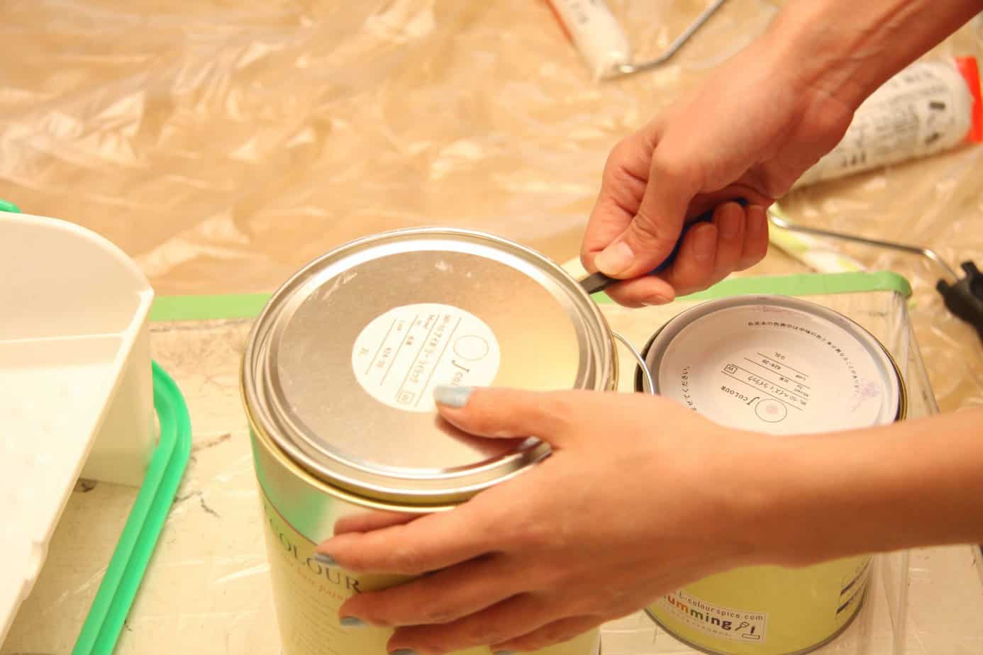 A person opening a can of paint