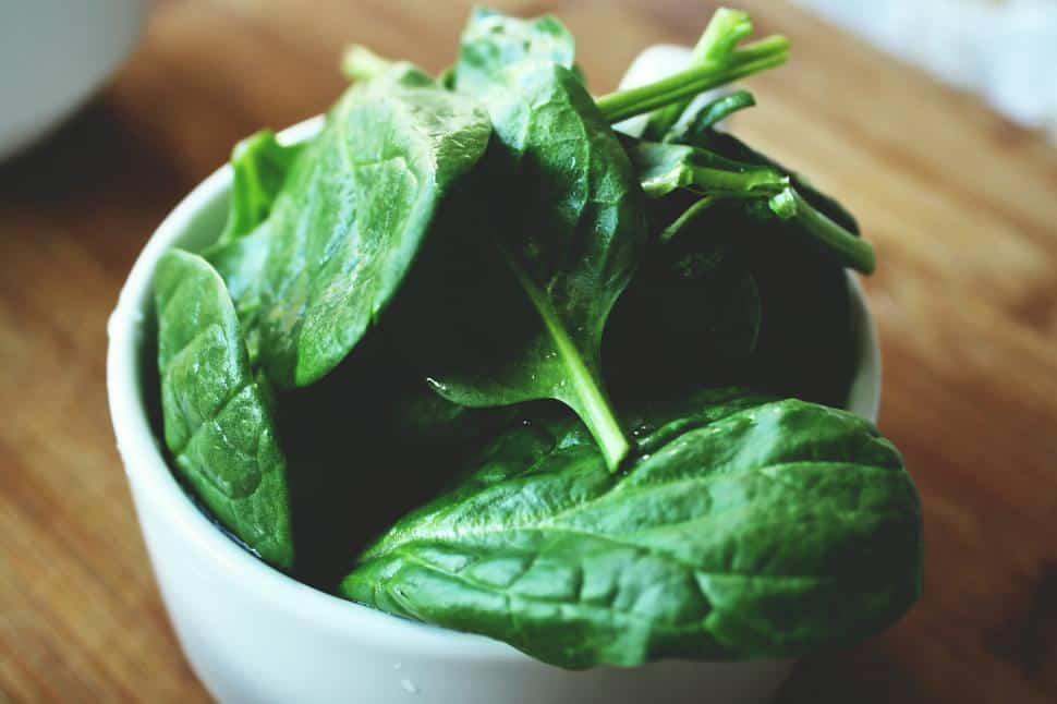 A bowl of spinach leaves.