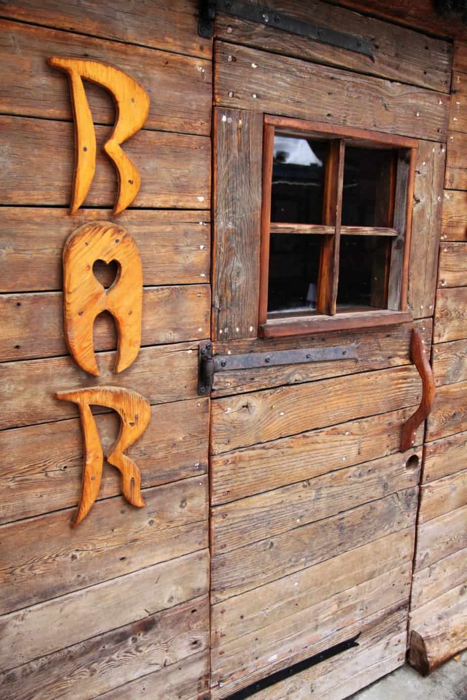 Garden bar shed with a wooden sign that says "BAR"