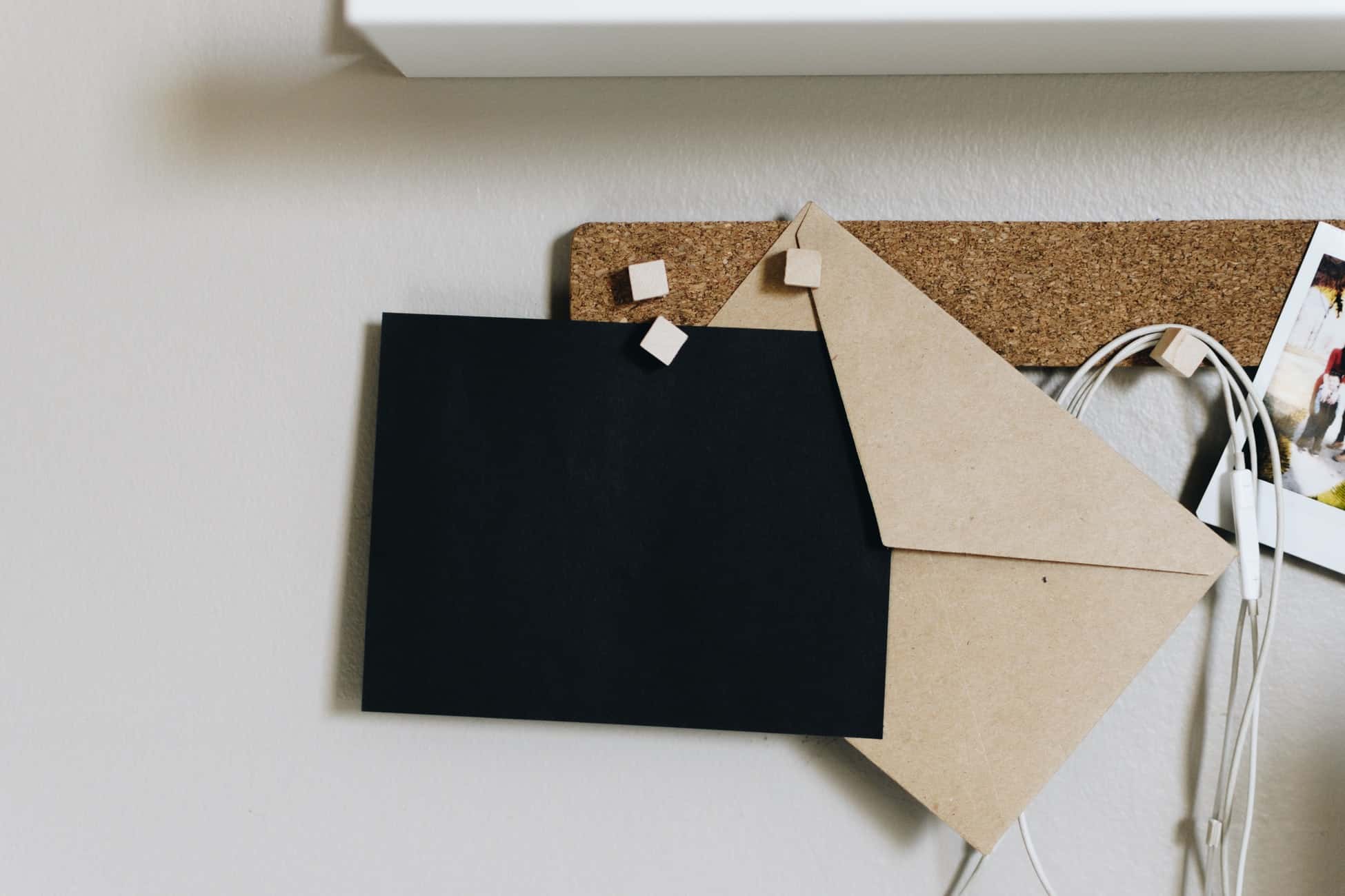 Cork board with envelopes and earphones on