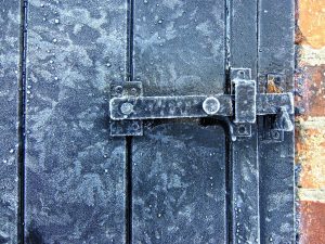 Black door bolt covered in frost