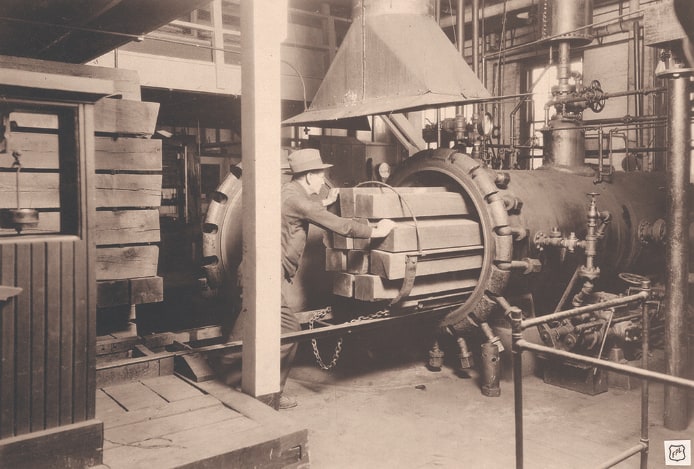 Sepia-toned image of a man inside a wood preservation research lab, diligently working on safeguarding wood from biological degradation.