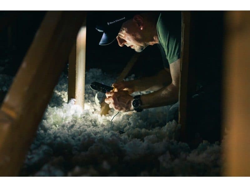 man with headlamp checking insulation