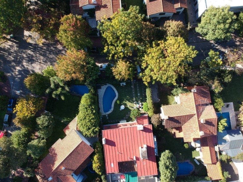 aerial views of houses, trees, and a pool