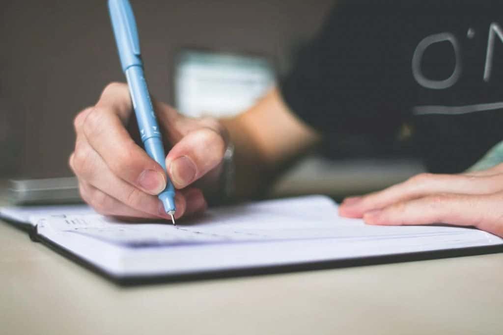 A person writing on a notebook