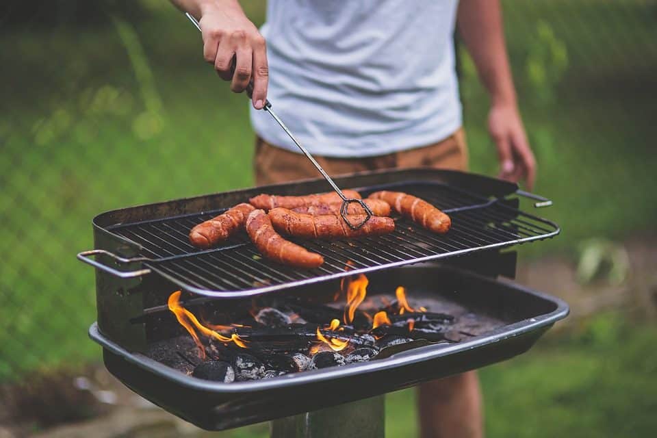 A man grilling sausages on the grill