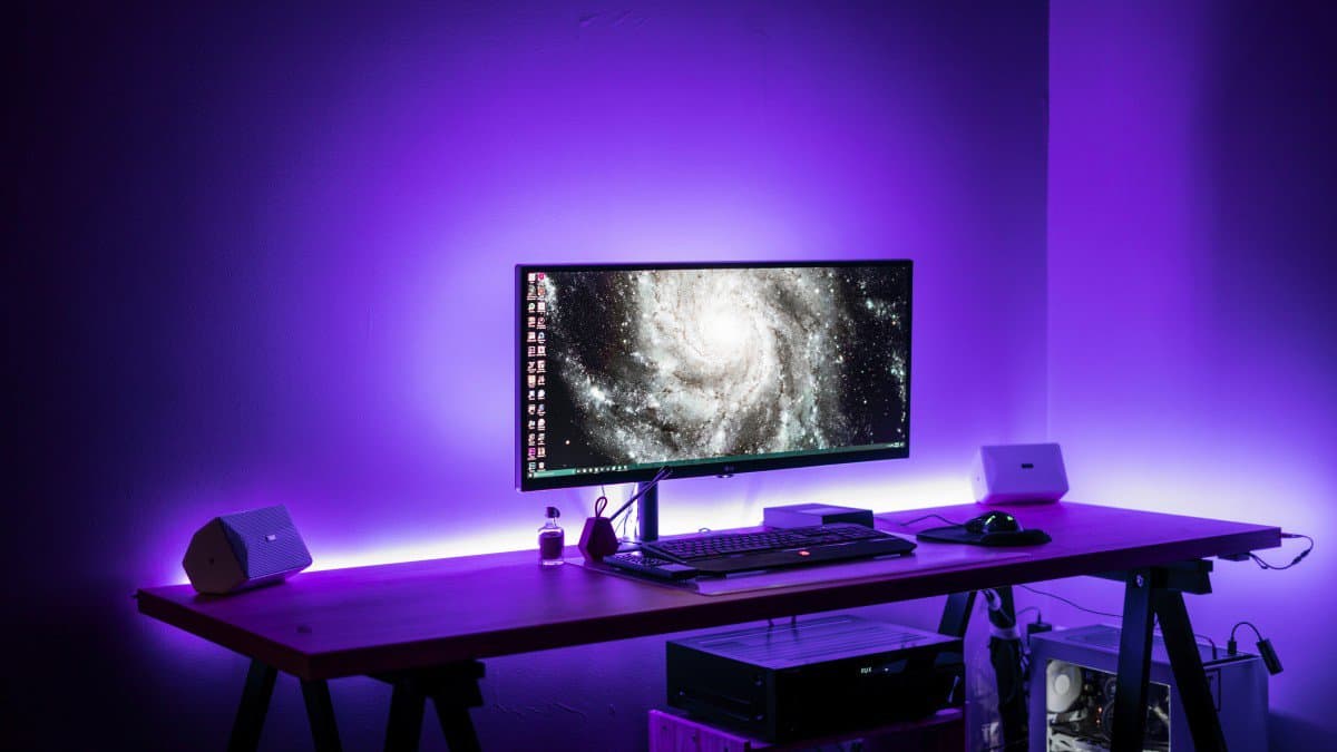 Gaming desk setup with purple strip lights