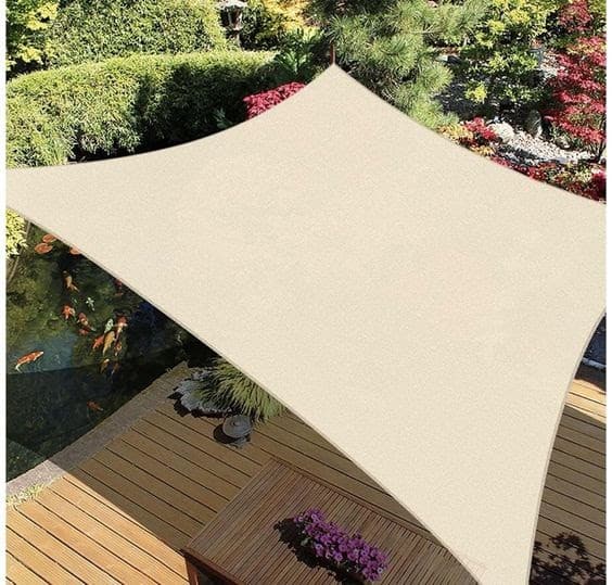 a square beige piece of cloth known as a sail canopy covering some decking