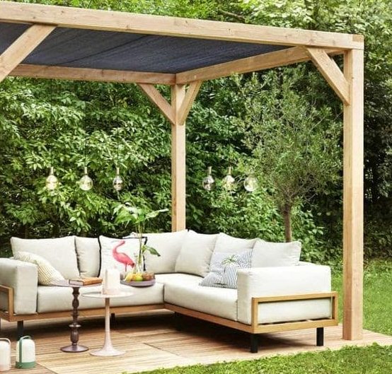 a pergola or canopy with some tarpaulin/a sheet of cloth draped on top to protect the garden furniture underneath and the belongings from the sun and anyone who's sitting there