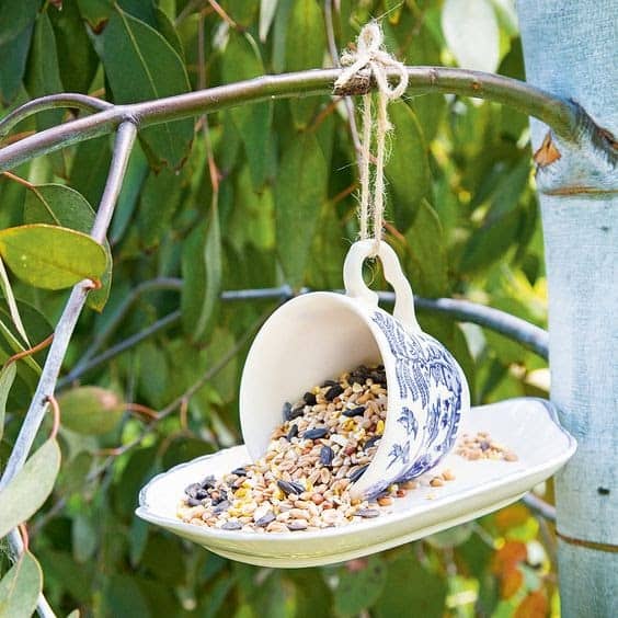 bird seed cup with up tilted mug held by string