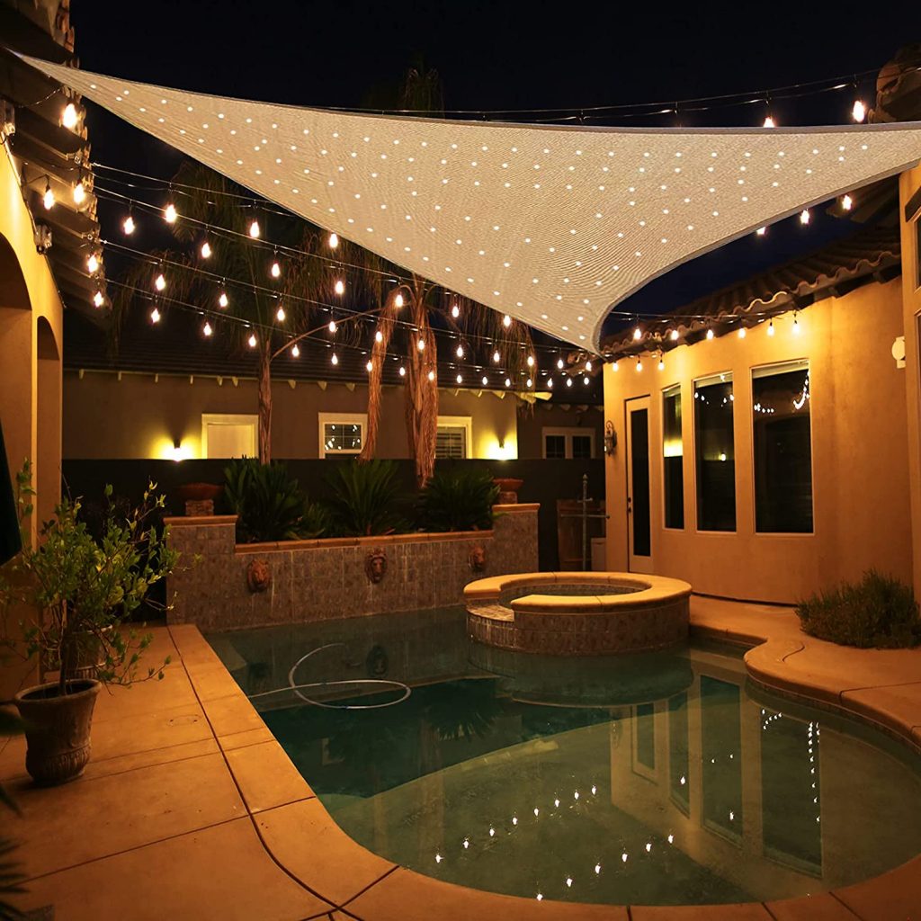 Backyard pool with canopy and string lights