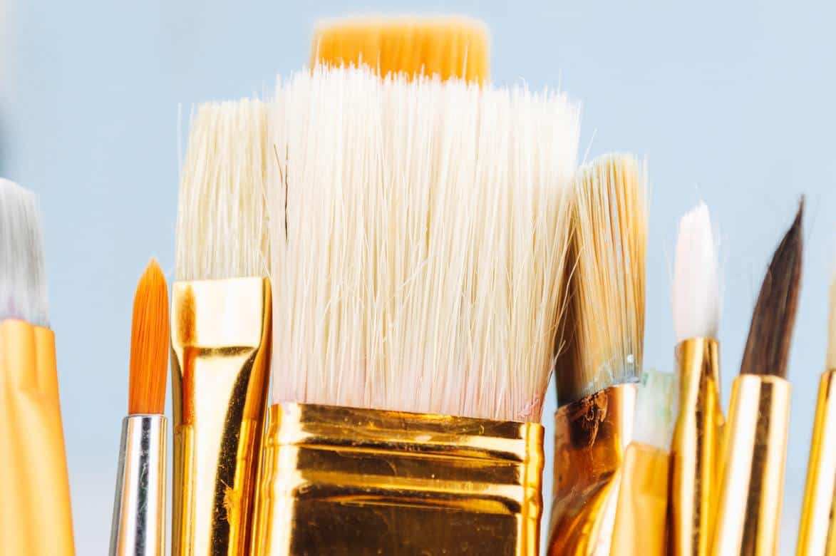 Various paintbrushes on a blue background
