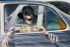 Laughing skeleton in cobwebbed car