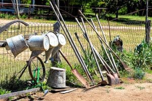 Garden tools leaned against a fence