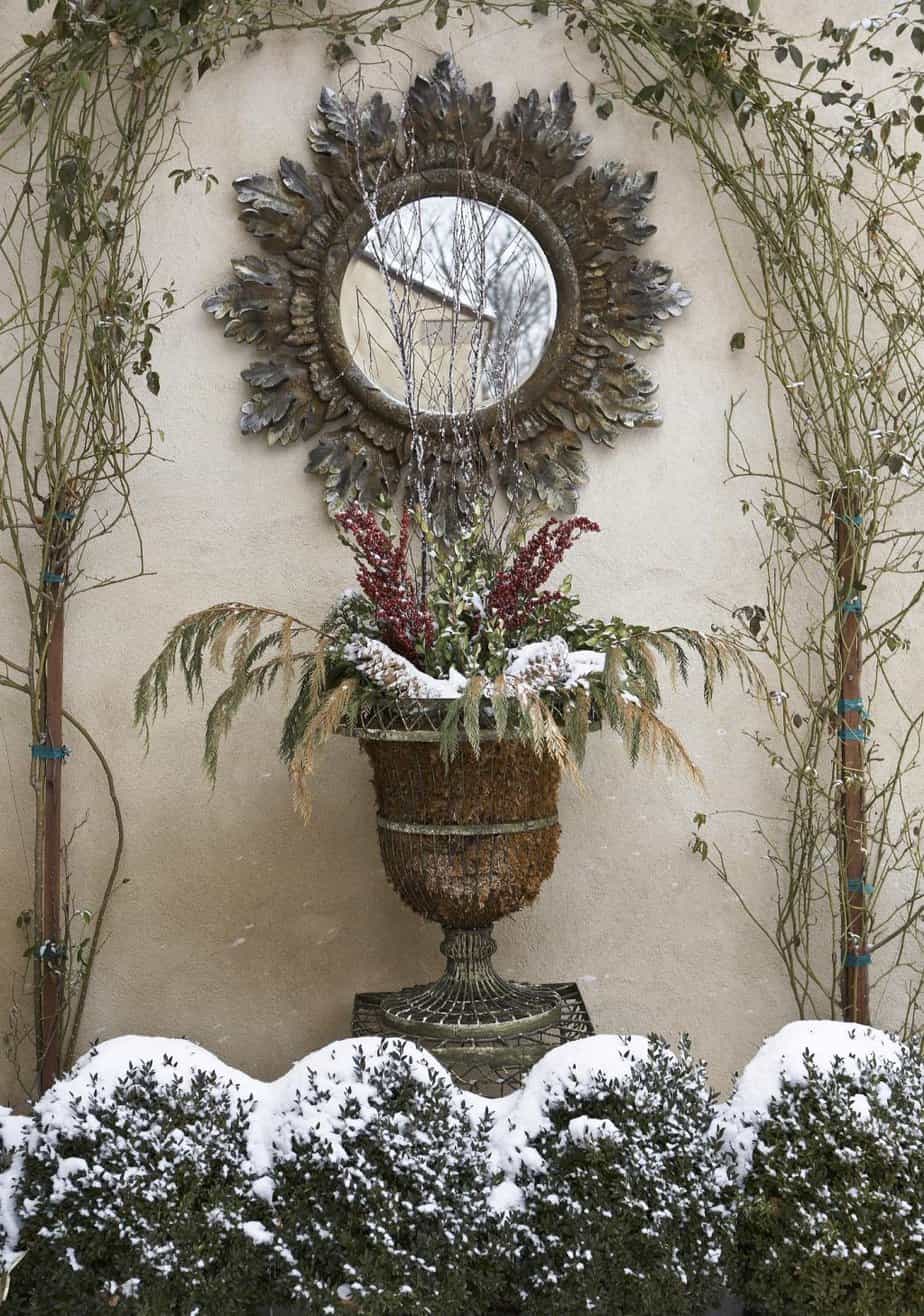 Rustic festive patio display with a mirror and greenery