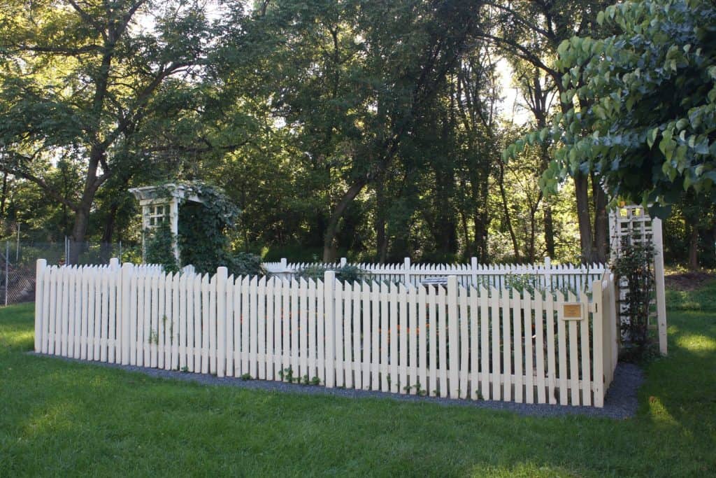 Vegetable garden with white fence and trellis