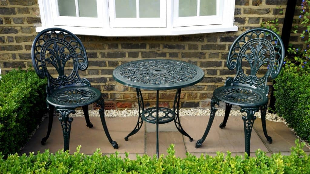 Wrought-iron bistro set on a corner concrete deck area