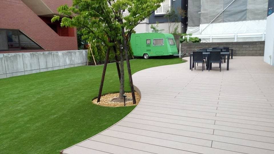 Curvy composite deck on the right and artificial lawn on the left side