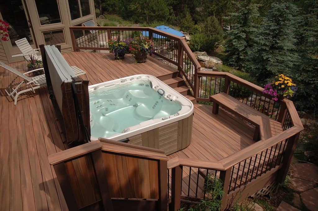 Outdoor hot tub on a deck with a forest view
