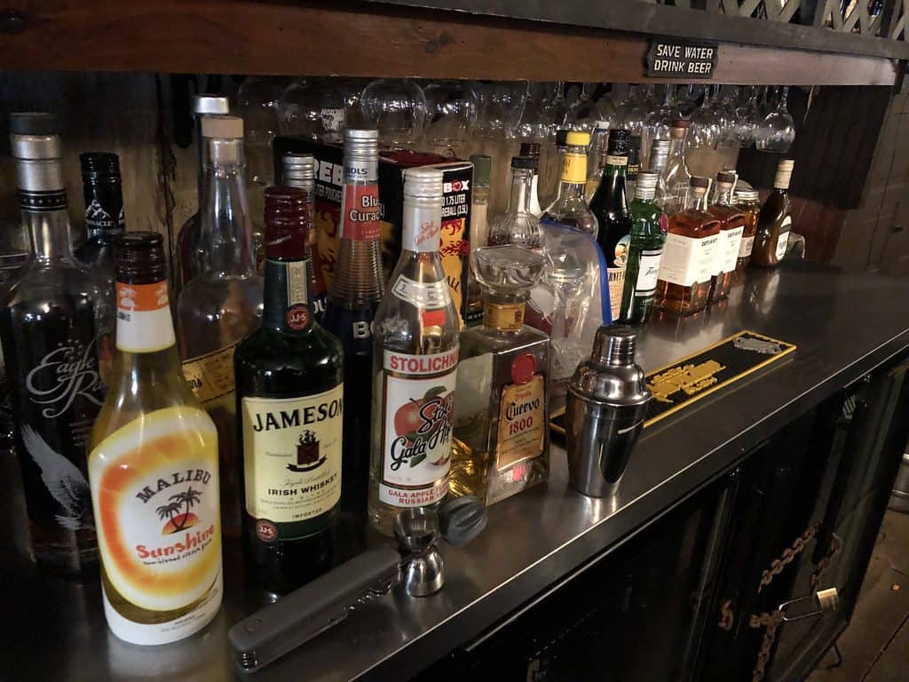 Bar side table filled with various alcohol drinks