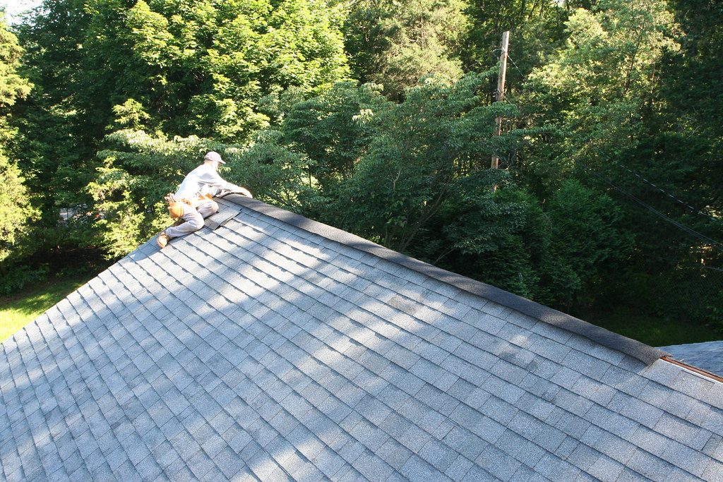 A man installing a ridge vent on the roof