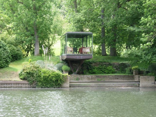 Floating glass summer house with a view of the lake and the forest