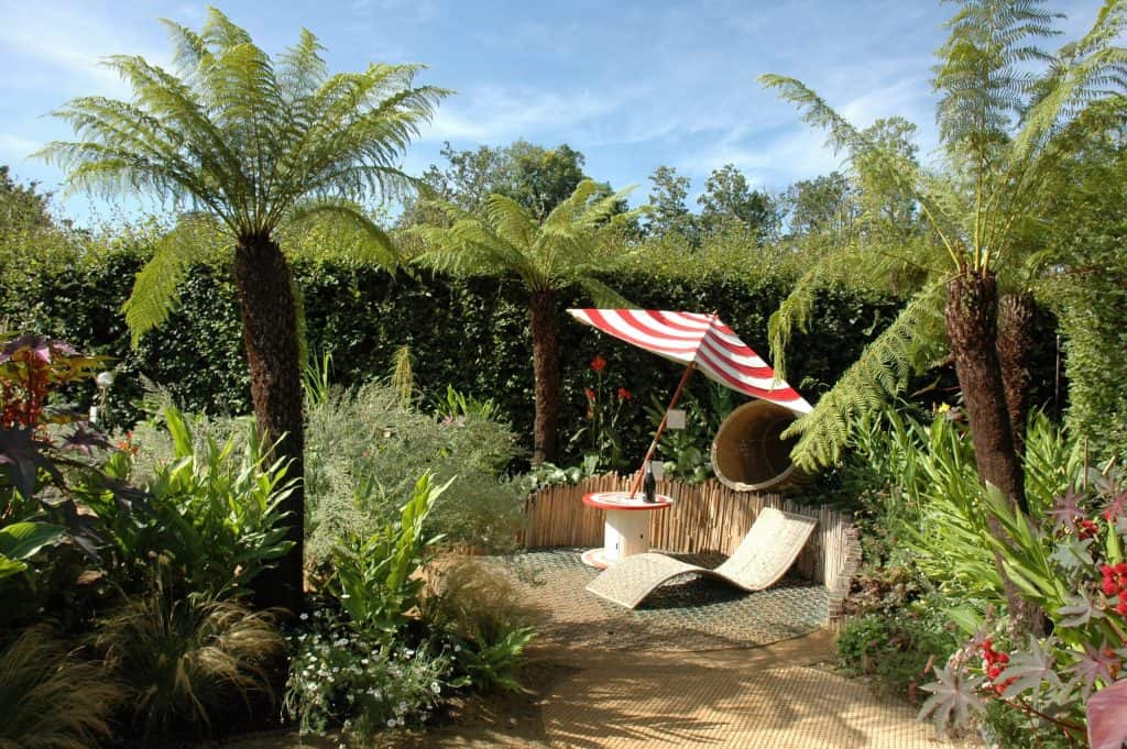 Tropical themed summer garden with red umbrella