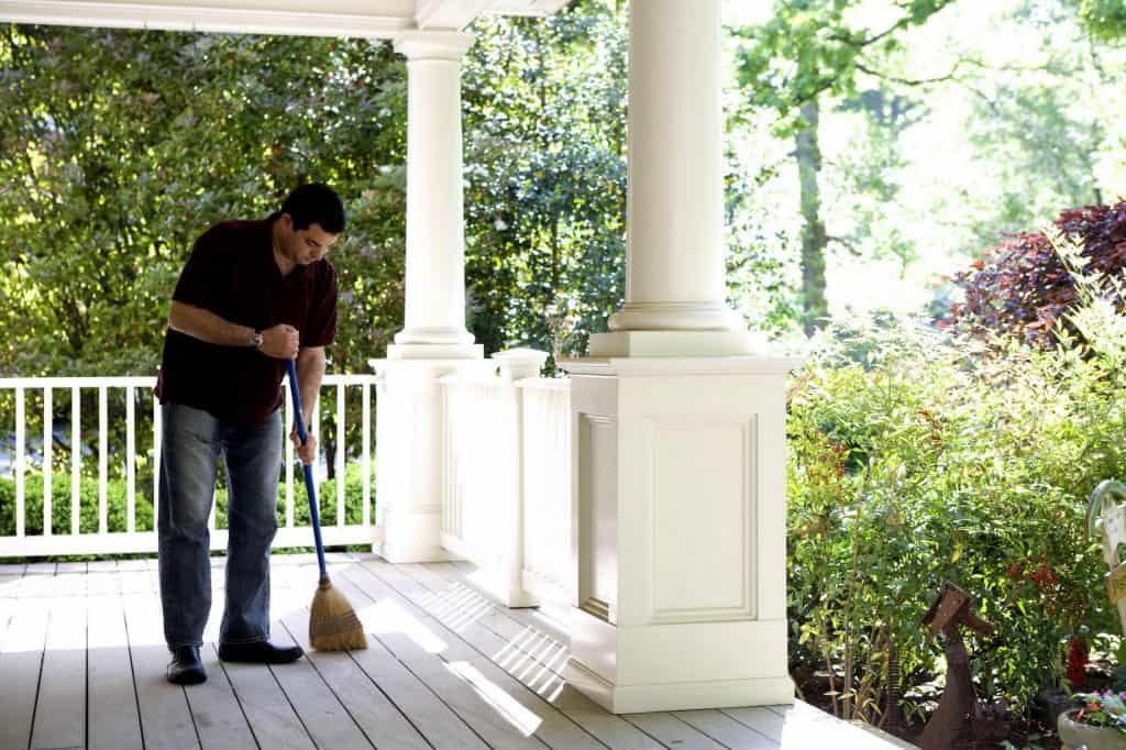 A man sweeping the porch deck