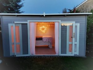 Carmen Log Cabin exterior decorated in grey and white in a garden