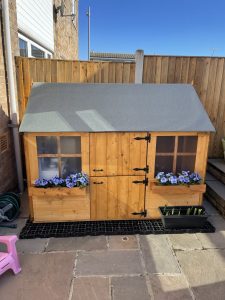 BillyOh Gingerbread Playhouse with flower decorations.