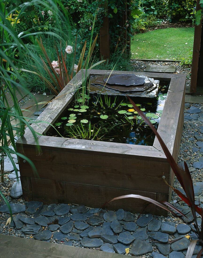 Raised wooden pond with waterlilies and slate water feature