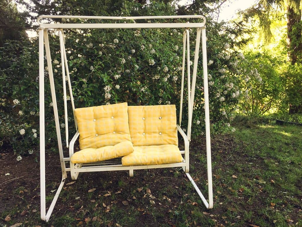 Garden swing with yellow cushions