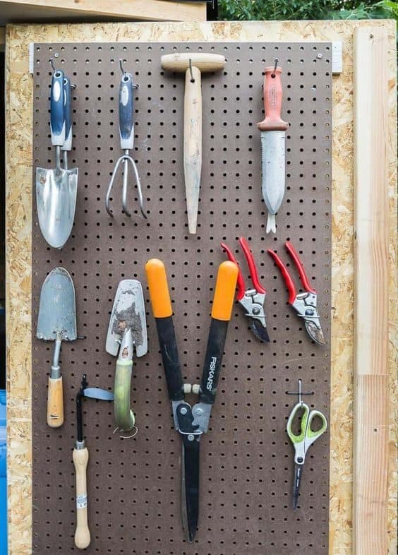 A vertical pegboard installed on a shed's back door.