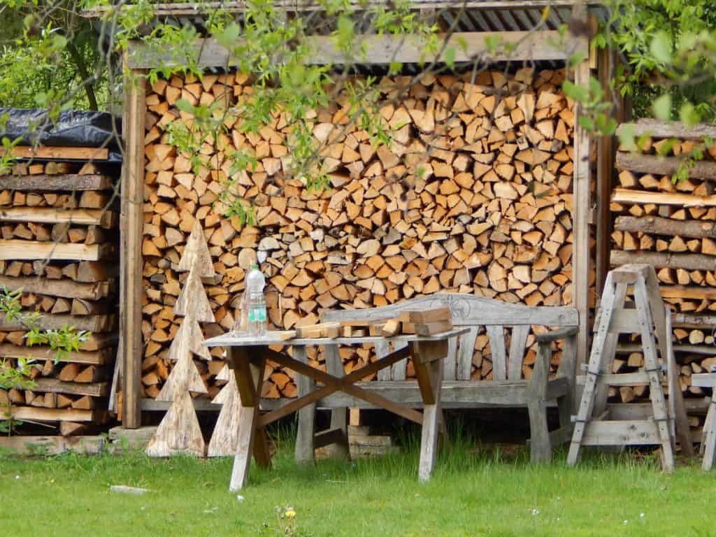 A pile of firewood log assorted neatly in a DIY rack.