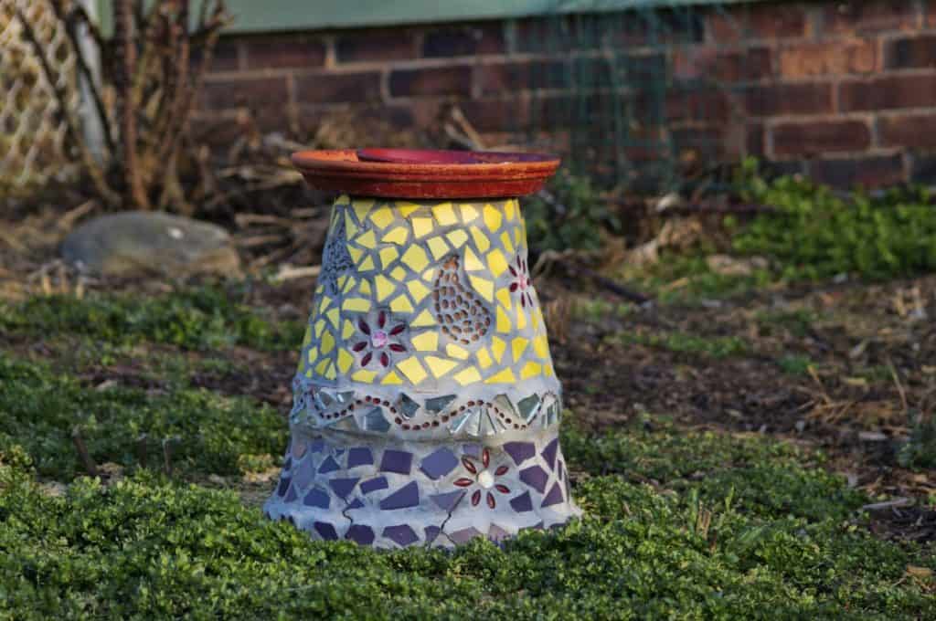 DIY mosaic bird bath situated in the garden