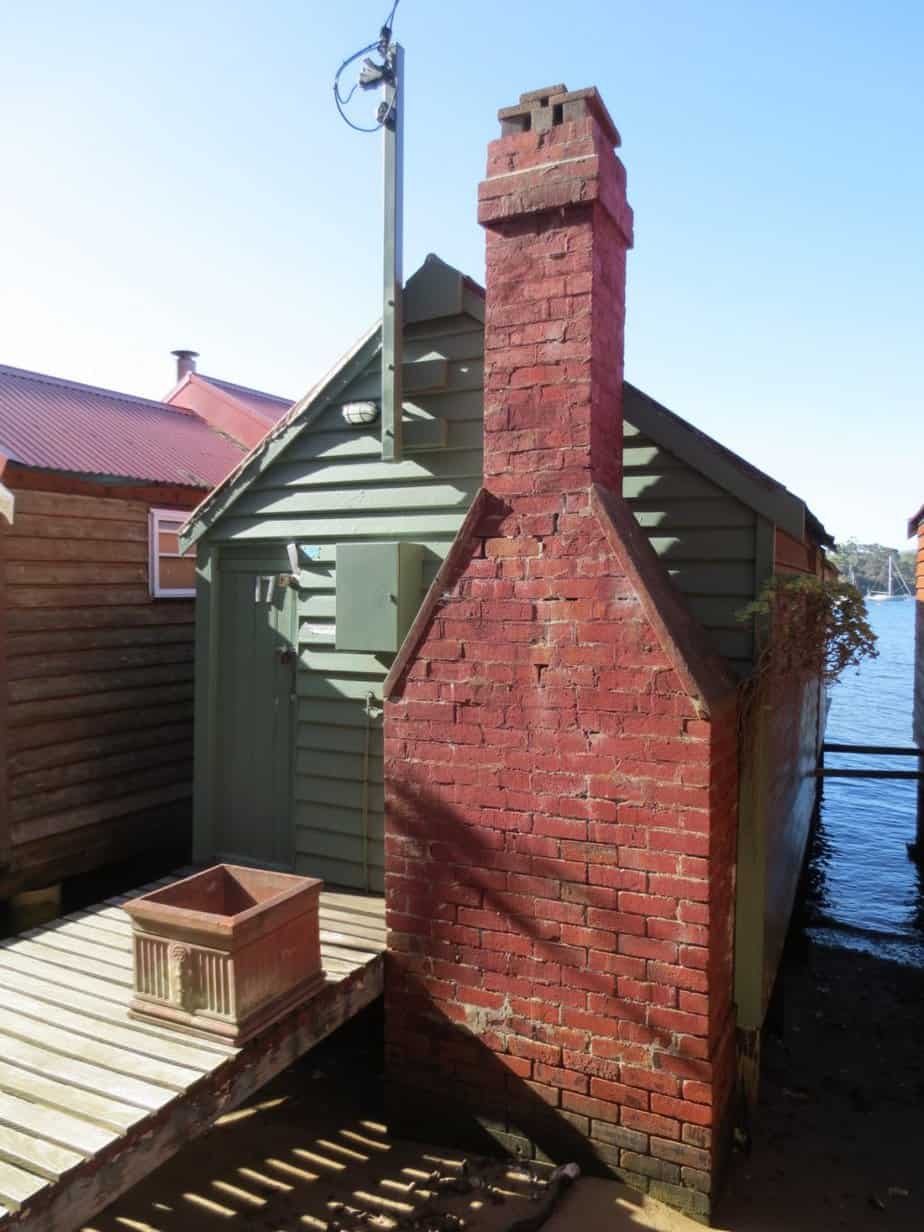 Mint-coloured garden building with brick-made chimney