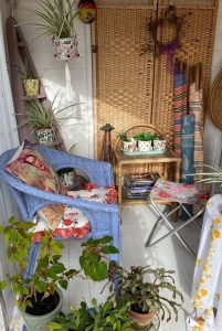 Sunny summer house interior with blue wicker chair and houseplants