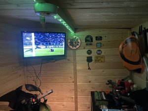 Shed interior with TV, wall decorations and neon lighting