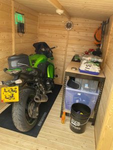 Shed interior with motorbike, workshop bench, and decorations