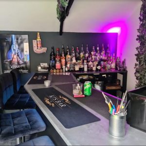 A bar setting in a shed with bar decorations and bottles of alcohol.