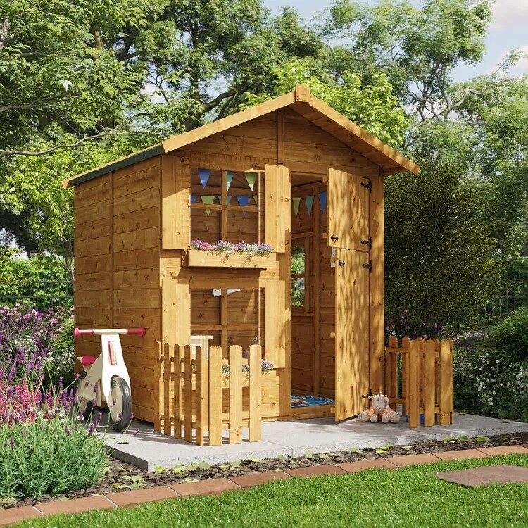 Two storey wooden playhouse in a grassy garden