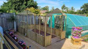 The frame of a wooden greenhouse under construction