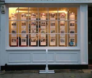 Estate agent window with property cards in late afternoon