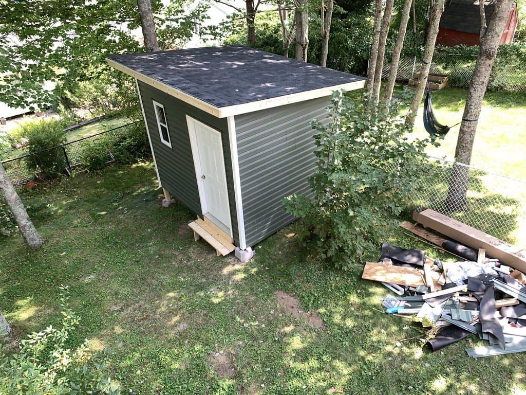 Mini lean-to shed leaning against a wire fencing